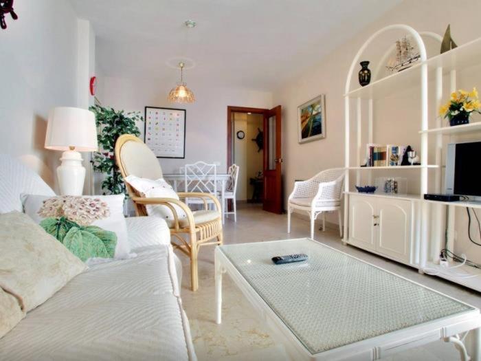 uma sala de estar com um sofá e uma mesa em Holi-Rent Veramar em Estepona