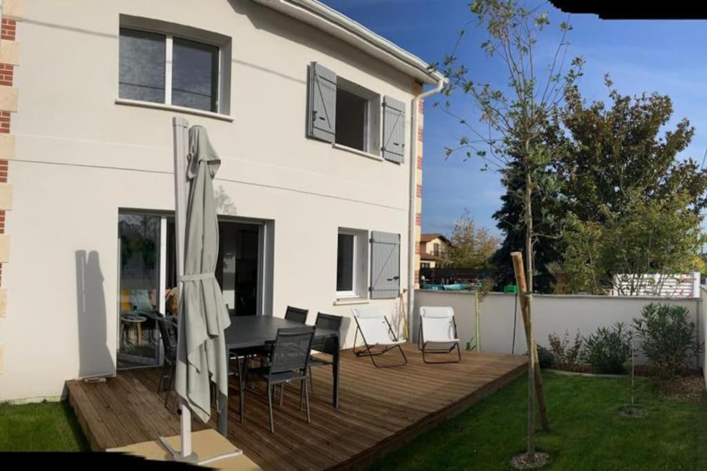 una terraza de madera frente a una casa blanca en VILLA MOANA en Andernos-les-Bains