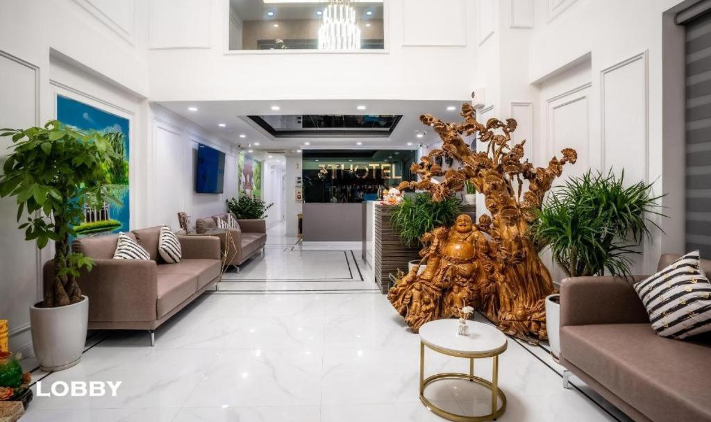 a lobby with couches and plants in a building at 3T Hotel 41 Nguyễn Thái Học- by Bay Luxury in Hanoi