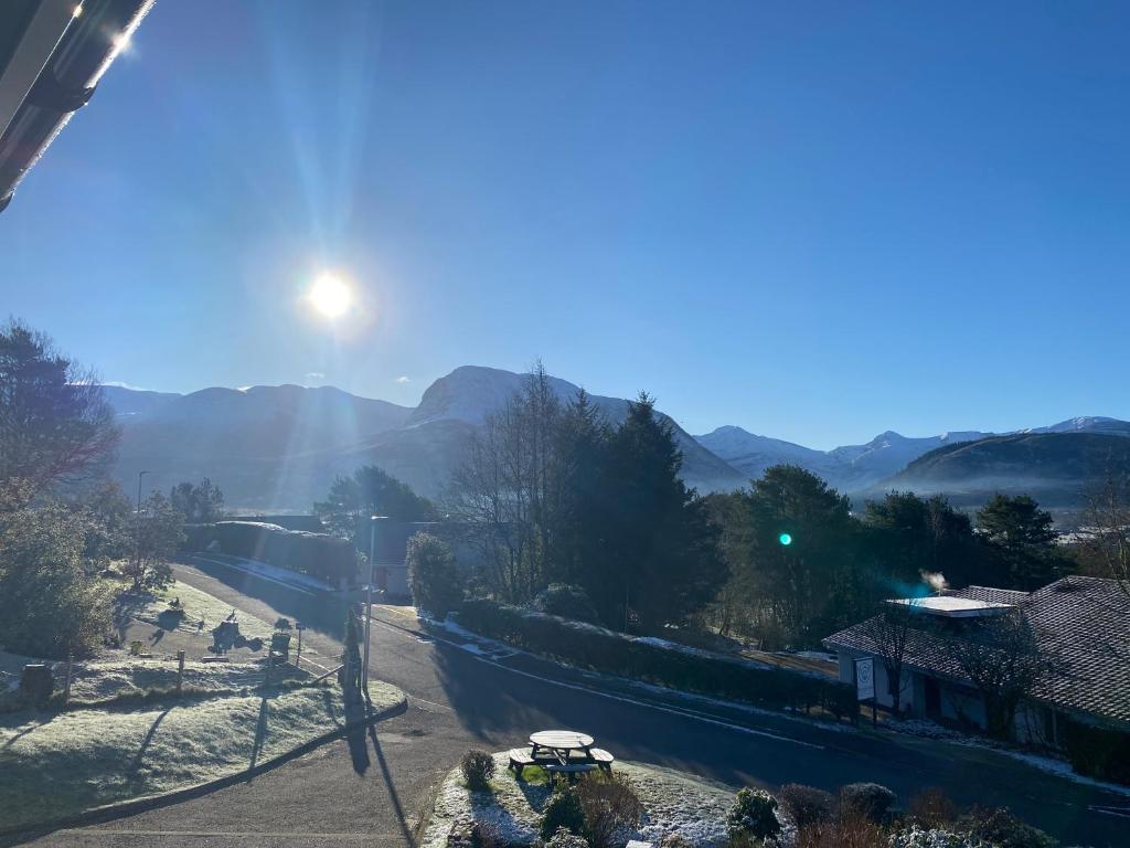 a view of a road with the sun in the sky at Innisfree Self Catering Apartment, Banavie, Fort William in Fort William