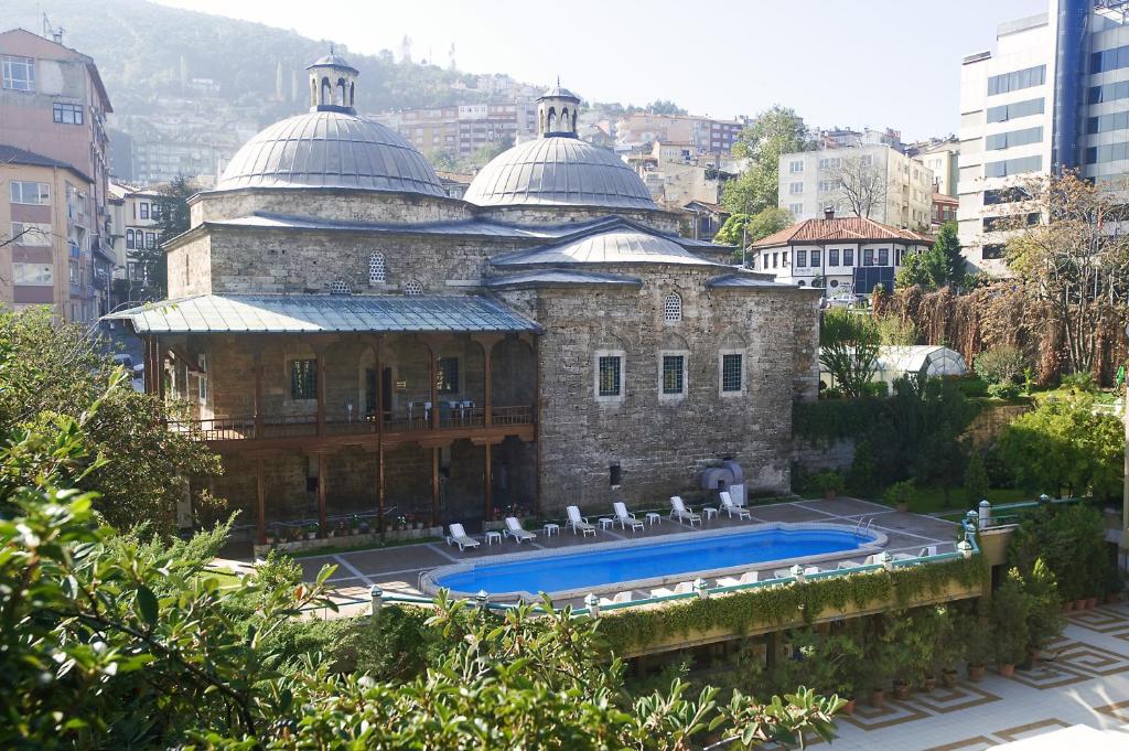 a building with a swimming pool in a city at Kervansaray Thermal Convention Center & Spa in Bursa
