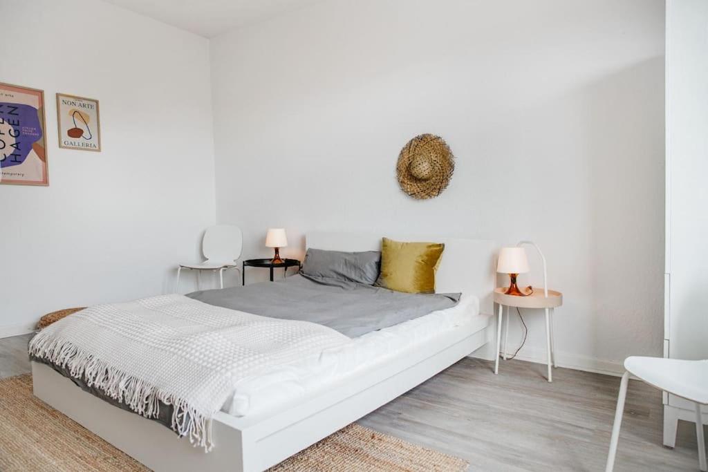 a white bedroom with a white bed and two tables at City-Appartement, Holtenauer Straße mit 24h Check-in in Kiel