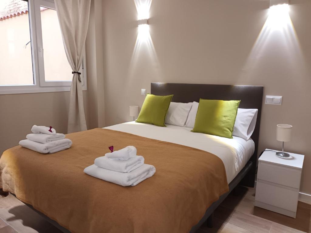 a bedroom with a bed with towels on it at La Casona del Eboni in Alcalá de Henares