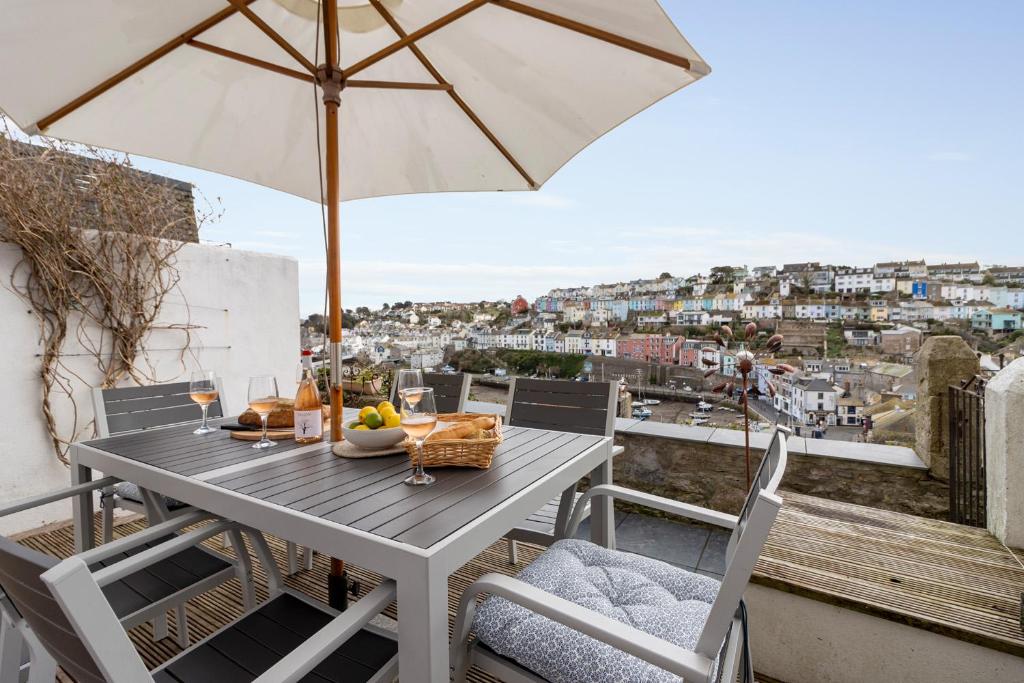 a table with an umbrella on a balcony at Polly's Place, Brixham in Brixham