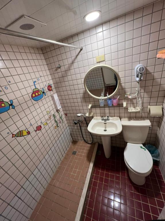 a bathroom with a toilet and a sink at Boston Hotel in Chiayi City