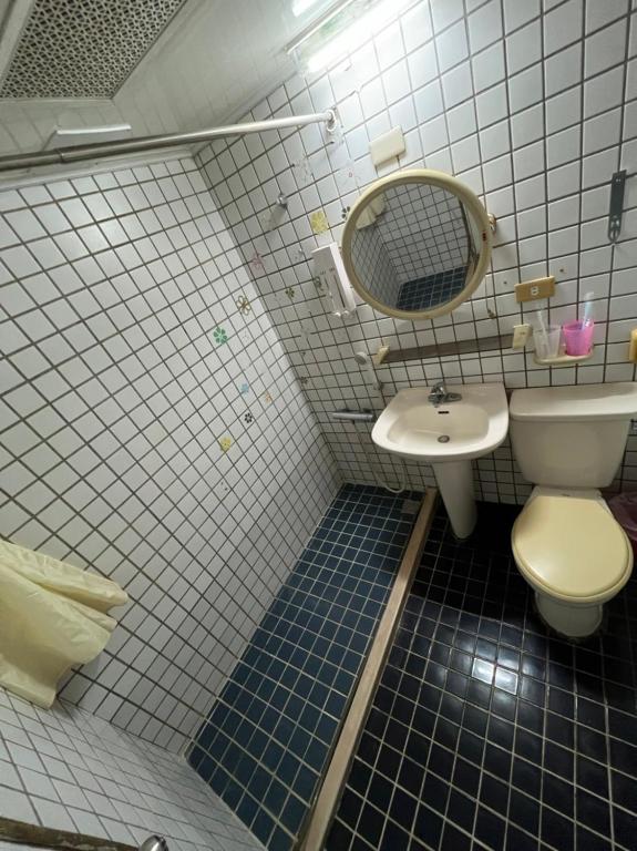 a bathroom with a toilet and a sink at Boston Hotel in Chiayi City