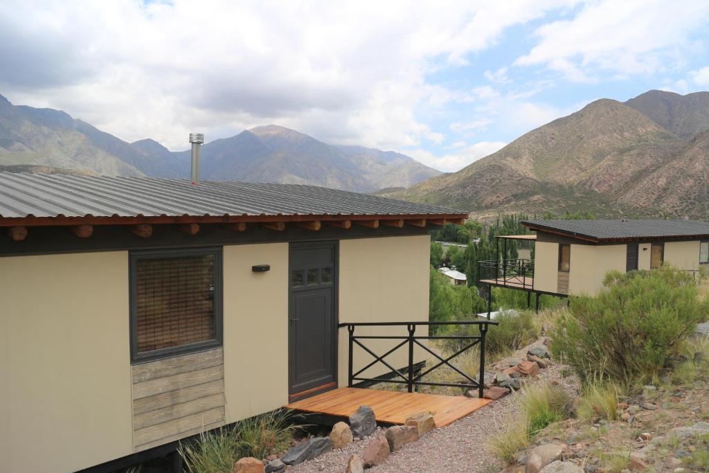 a house with a deck and mountains in the background at Chalet Vista Montana in Potrerillos