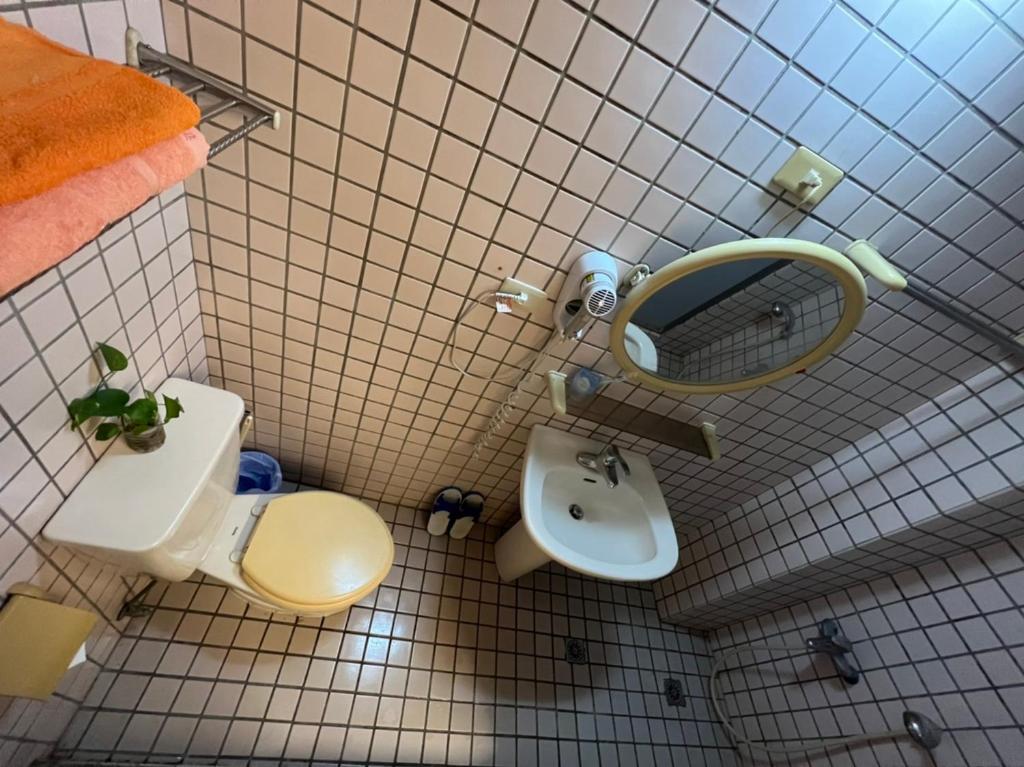 a bathroom with a toilet and a sink and a mirror at Boston Hotel in Chiayi City