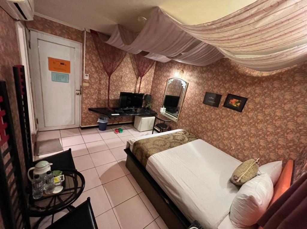 a bedroom with a bed and a mirror and a television at Boston Hotel in Chiayi City