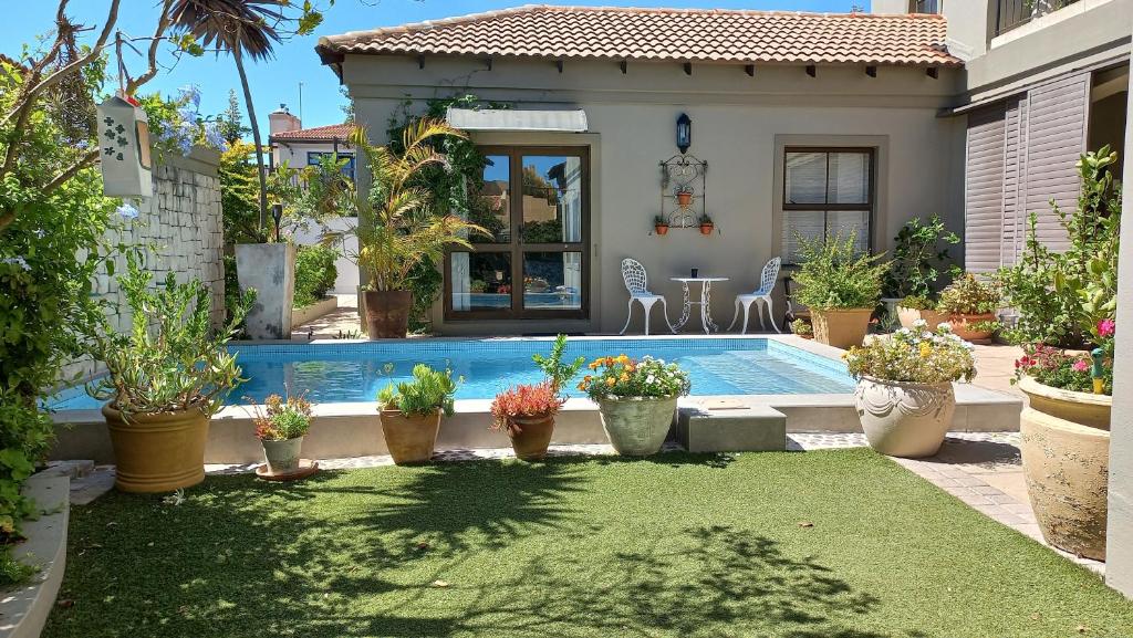 a house with a swimming pool with potted plants at Big Bay Homestay in Big Bay