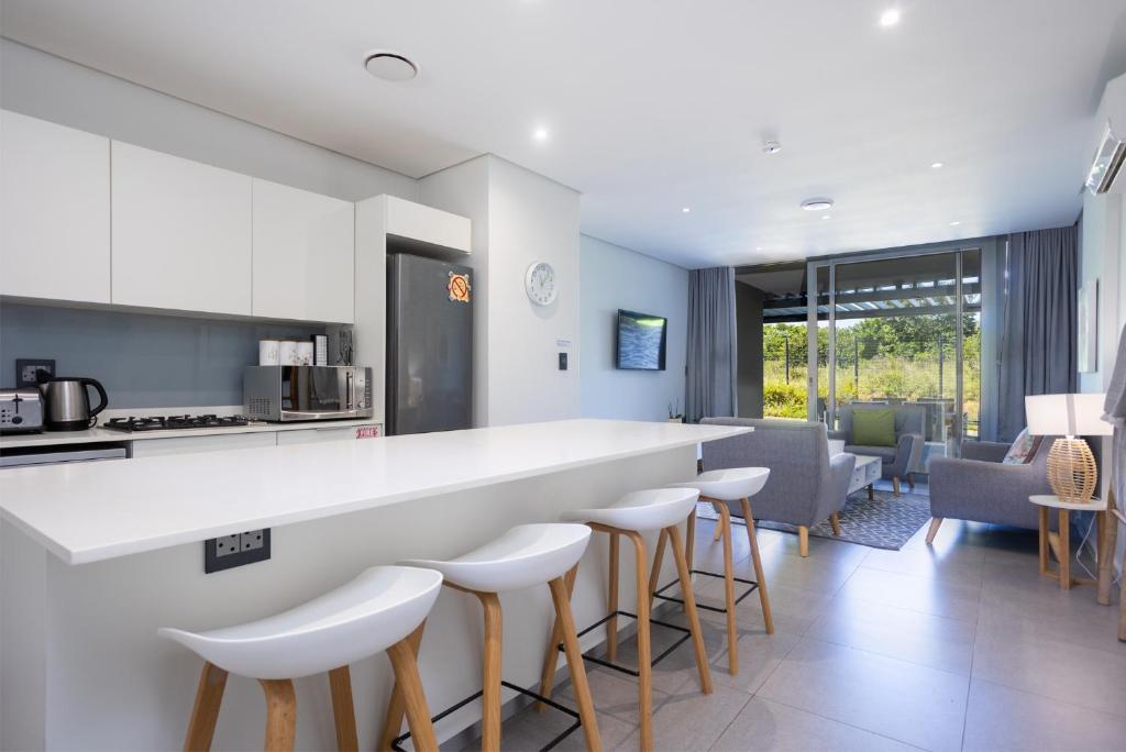 a kitchen with a counter and stools in a room at Modern Garden Unit in Pebble Beach in Umhlanga