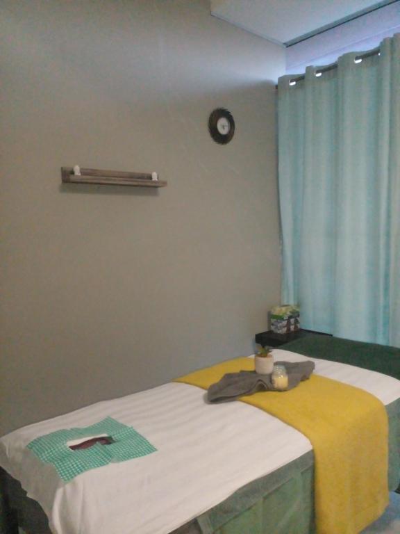 a bedroom with a bed with a yellow and white blanket at DeeCinta Health Spa in Johannesburg