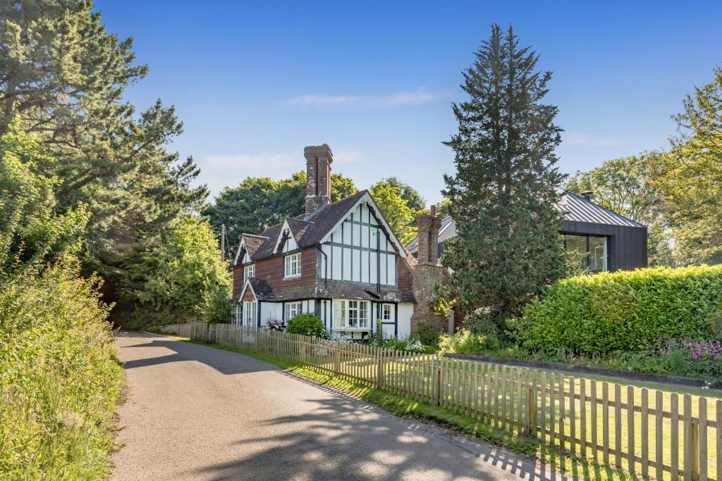 a house with a fence next to a road at Danny Lodge - Country Cottage Near Brighton by Huluki Sussex Stays in Hurstpierpoint