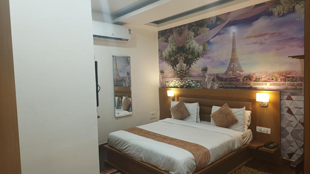 a bedroom with a bed with a painting of the eiffel tower at Banyan hotel&restro in Hisār
