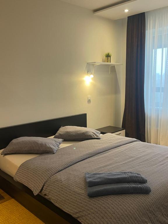 sypialnia z łóżkiem z niebieskim ręcznikiem w obiekcie Dainu street apartament w Szawlach