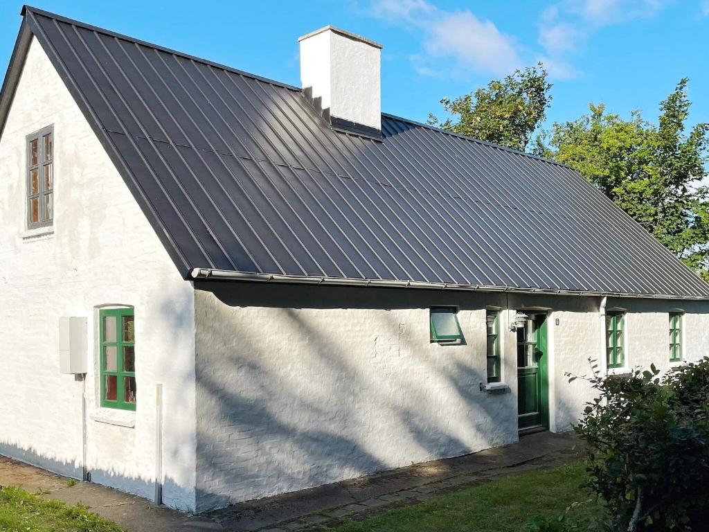 una casa blanca con techo negro en Holiday home Bedsted Thy IV, en Bedsted Thy