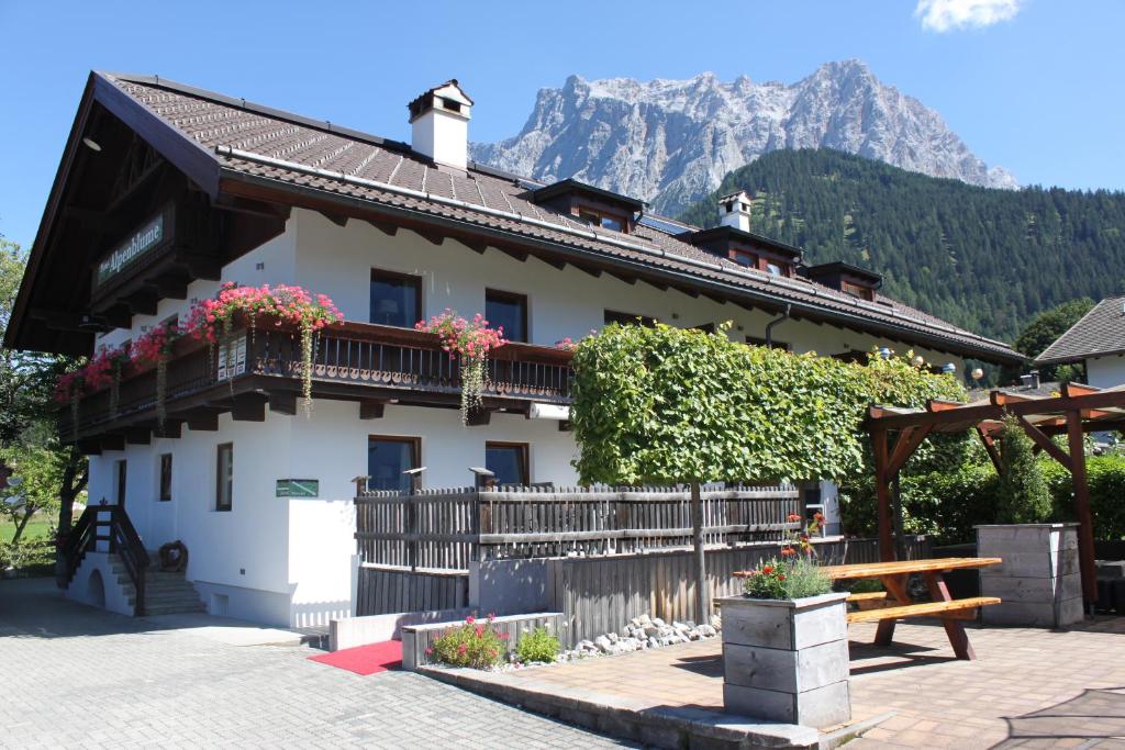 ein Haus mit einer Bank und einem Berg im Hintergrund in der Unterkunft Haus Alpenblume in Ehrwald