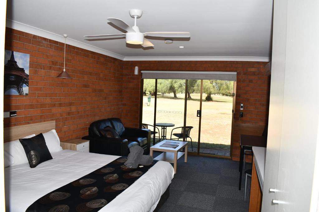 una camera con letto e muro di mattoni di Berrigan Motel a Berrigan