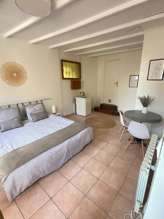 une chambre avec un grand lit et une table dans l'établissement La Fontaine de Vinsobres, à Vinsobres