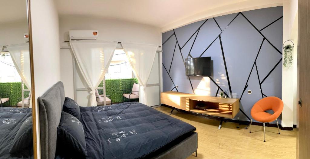 a bedroom with a bed and a tv on a wall at Bat Galim - Mirror Apartment by the beach in Haifa
