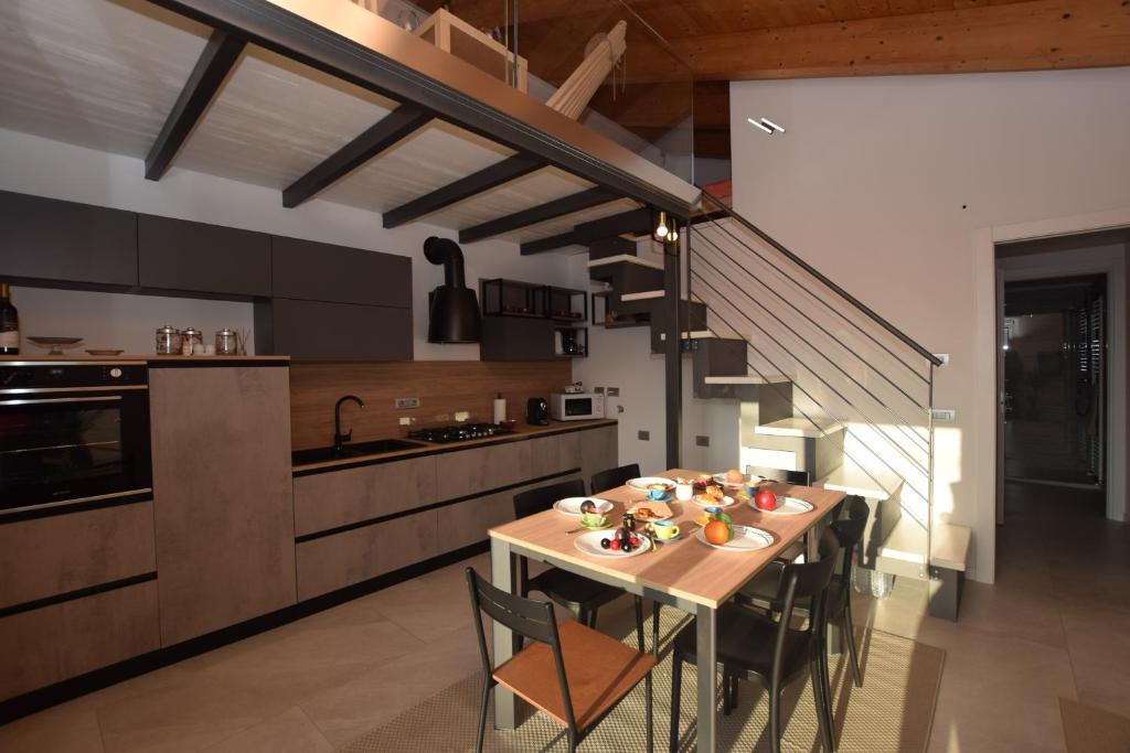 eine Küche mit einem Tisch mit Stühlen und einer Treppe in der Unterkunft Casa Silù - Lago di Como in Colico