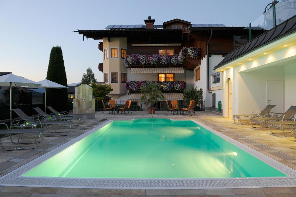 a swimming pool in front of a house at Pension St. Florian in Sankt Johann im Pongau