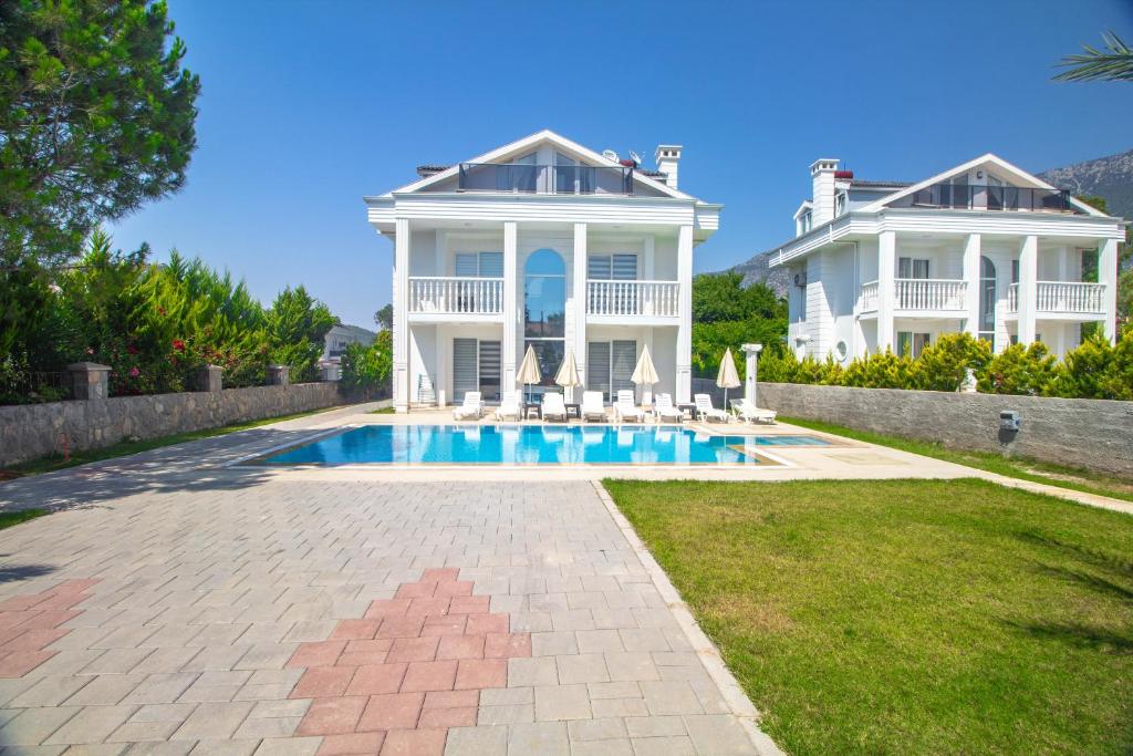 a large white house with a swimming pool at Hanımeli Villa, Özel Havuzlu, Fethiye in Fethiye