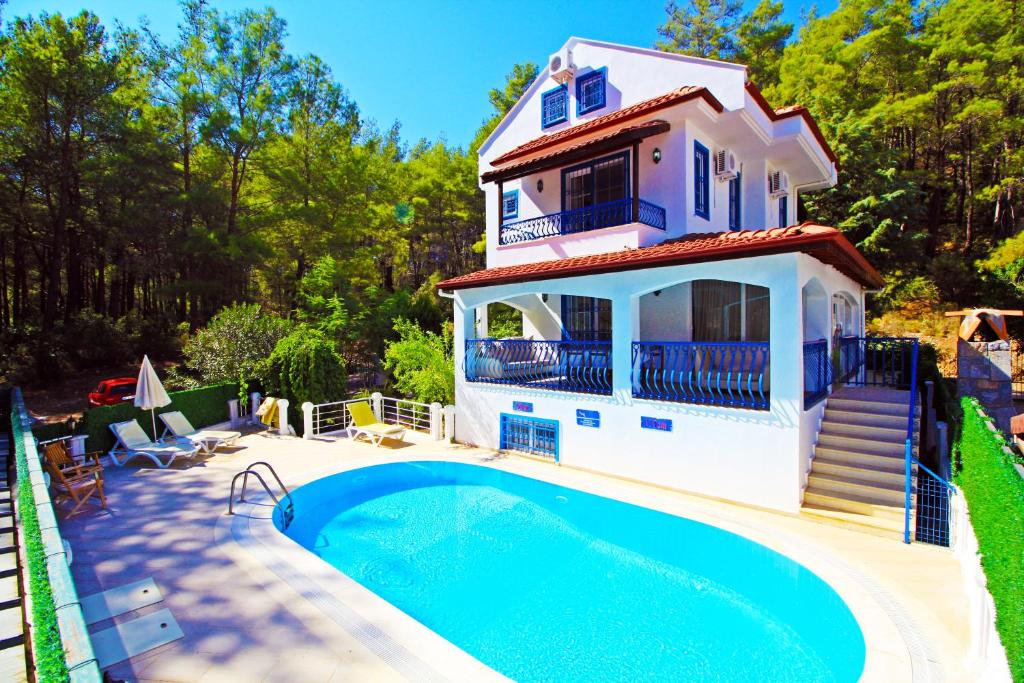 a villa with a swimming pool in front of a house at Brookland Paris, Özel Havuzlu, Fethiye in Fethiye
