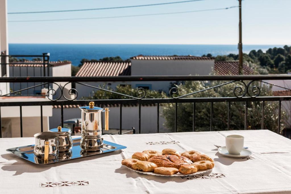 une table avec une assiette de pâtisseries sur un balcon dans l'établissement Pearl Suite Apartment, à Cala Gonone