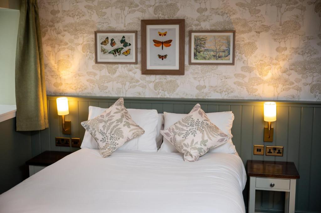 a bedroom with a bed with white sheets and pillows at Ardencaple Hotel by Greene King Inns in Rhu