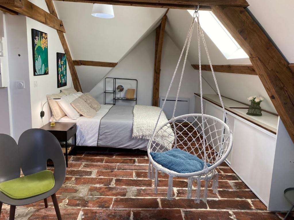 een slaapkamer met een schommel op zolder bij Appartements Charles de Gaulle in Joigny