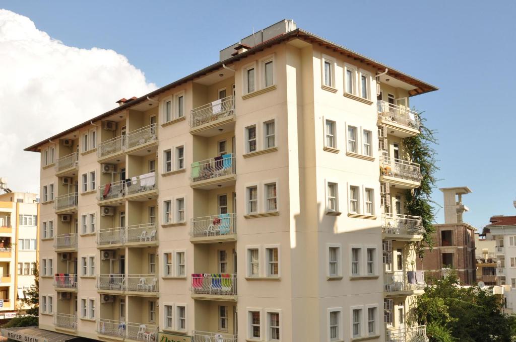 un edificio de apartamentos alto y blanco con balcones en Narcis Apart Hotel, en Alanya