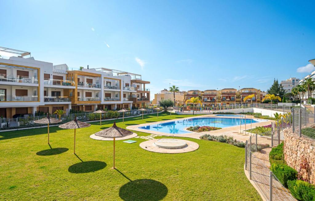 a large yard with a swimming pool with umbrellas at Residentie GALA in Orihuela