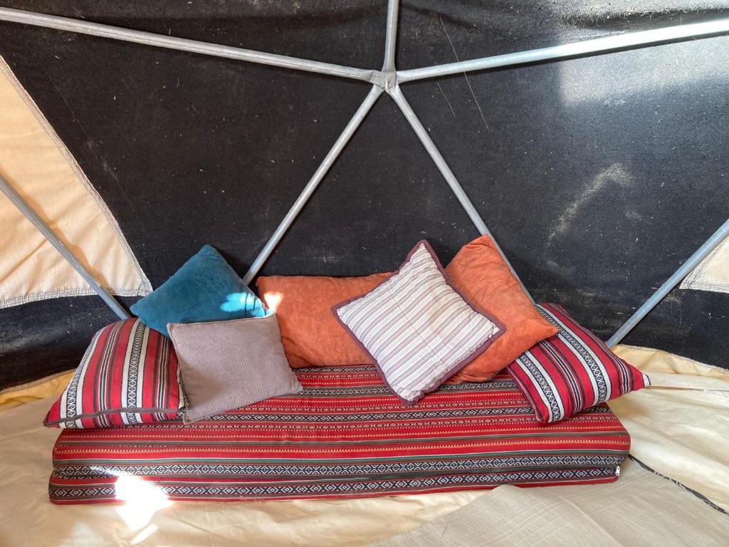 a group of pillows on a bed under an umbrella at Skyline eco-camp in Mitzpe Ramon