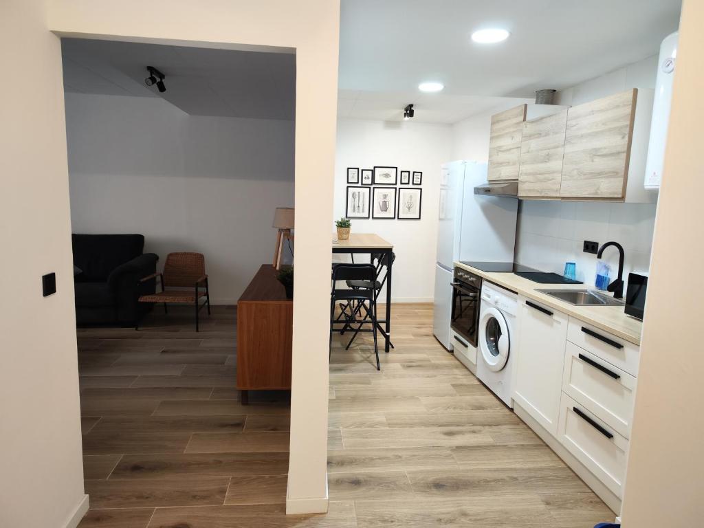 een keuken en een woonkamer met een wasmachine en droger bij BOUTIQUE 1 Apartment AVE Centro Lleida in Lleida