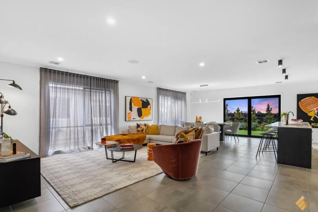a living room with a couch and a table at Brand New Modern 4 Bedroom Luxury Retreat in Caroline Springs