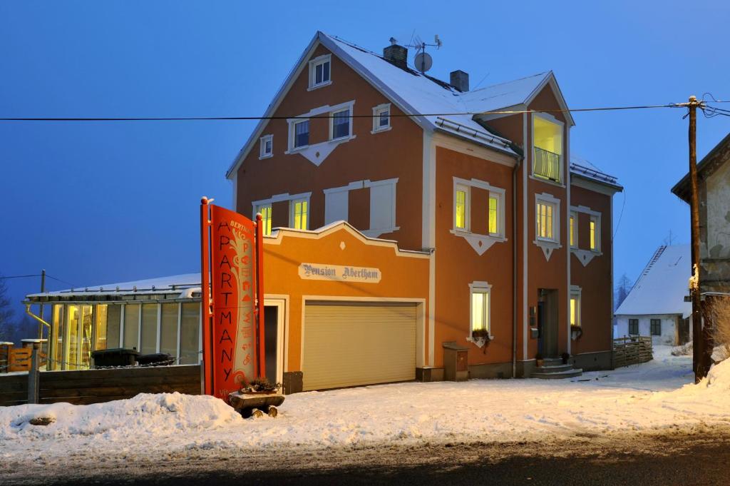 a large house with a garage in the snow at Resort Abertham - apartment Vanessa in Abertamy