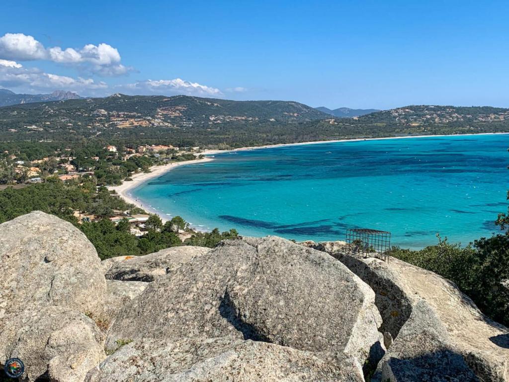 een uitzicht op een strand met rotsen en de oceaan bij Hôtel Spa & Restaurant - Son de Mar in Porto-Vecchio