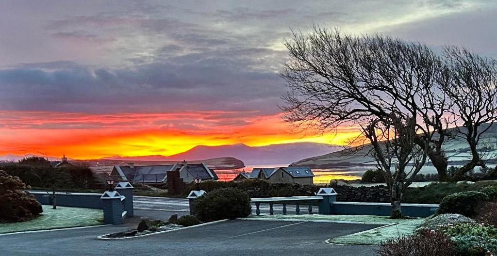 a sunset with a bench in a parking lot at Cill Bhreac House B&B in Dingle