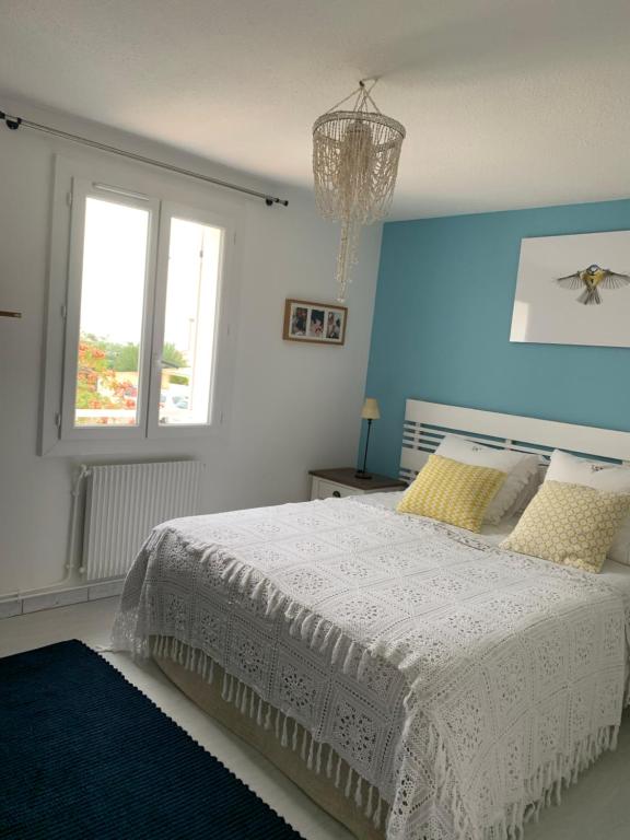 een slaapkamer met een wit bed en een raam bij Appartement supérieur sur l 'étang in Sète