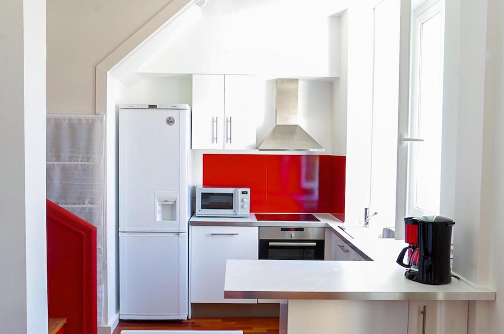 a kitchen with a white refrigerator and a microwave at Sainte Catherine - Duplex 1 chambre in Bordeaux