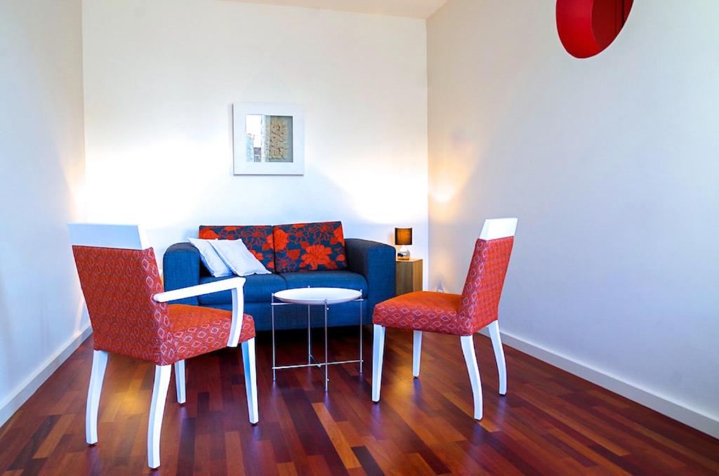 uma sala de estar com um sofá azul e duas cadeiras em Sainte Catherine - Duplex 1 chambre em Bordeaux