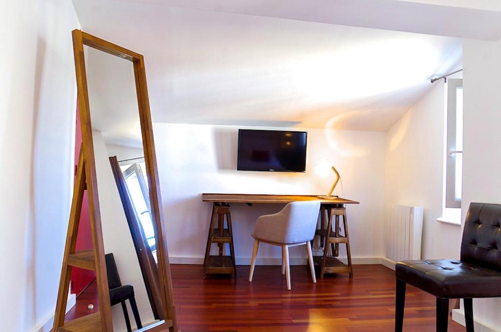 a living room with a table and a mirror at Sainte Catherine - Duplex 1 chambre in Bordeaux