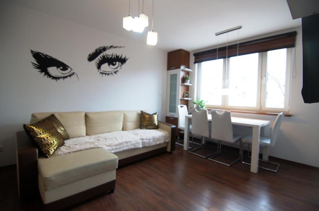 uma sala de estar com um sofá e um olho na parede em Apartament tuż za rogiem Zamku em Malbork