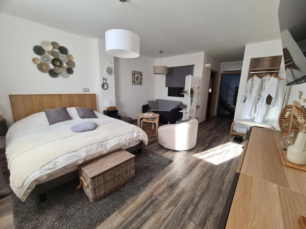 ein Schlafzimmer mit einem großen Bett und ein Wohnzimmer in der Unterkunft La suite Volupté - SPA du Souffle du Saule in Buhl-Lorraine