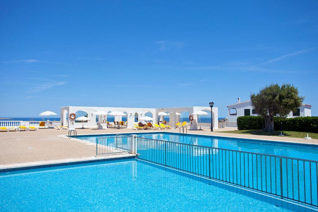 a swimming pool in a resort with a blue sky at Seth Sa Mirada in Arenal d'en Castell