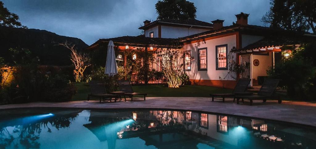 a house with a swimming pool in front of a house at Amana Tiradentes in Tiradentes