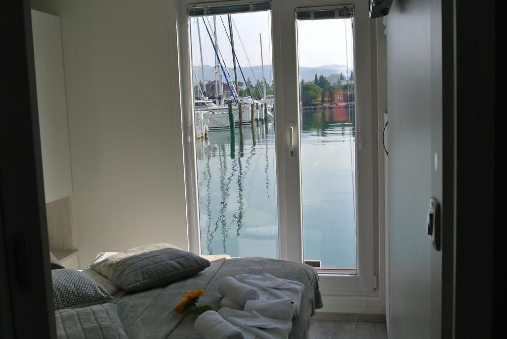 a bedroom with a bed and a view of the water at Stella blue Floating House Portorož in Portorož