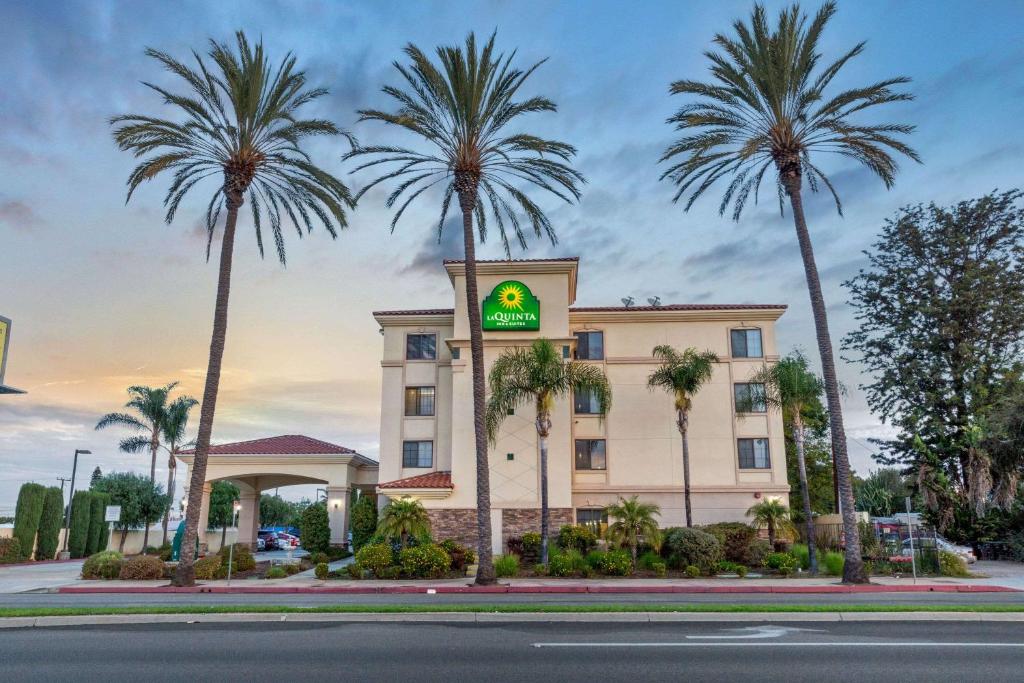 ein Hotel mit Palmen vor einem Gebäude in der Unterkunft La Quinta by Wyndham NE Long Beach/Cypress in Hawaiian Gardens