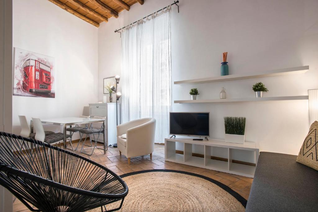 ein Wohnzimmer mit einem TV und einem Esszimmer in der Unterkunft Imperial Loft in Rom